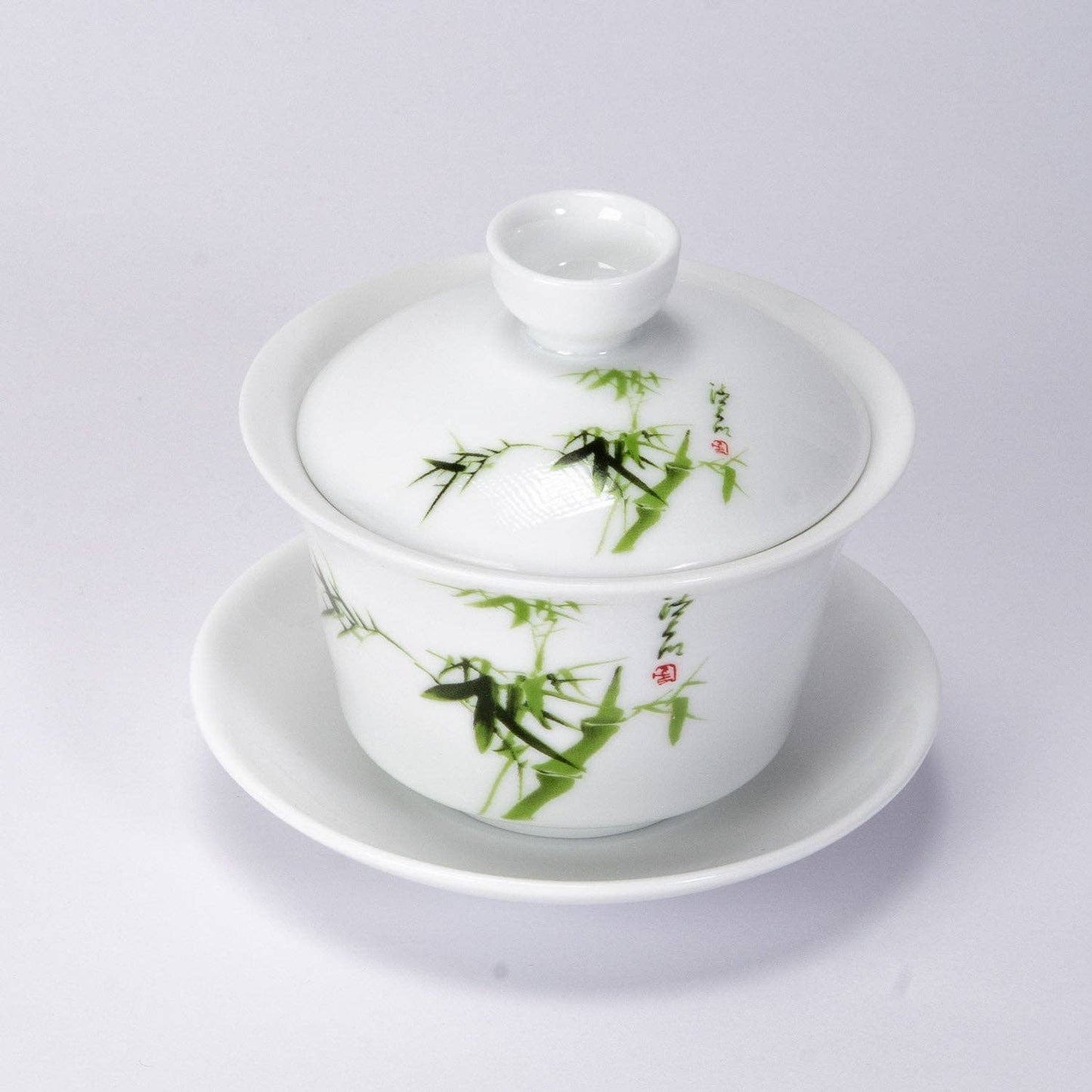 White ceramic teapot with green bamboo design on a white background