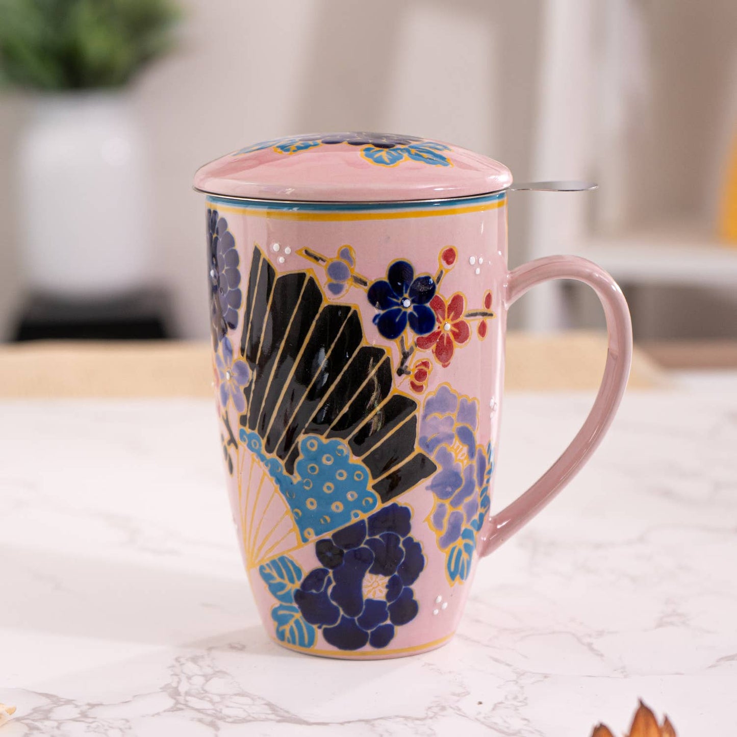Decorative mug with floral and fan design on a marble surface
