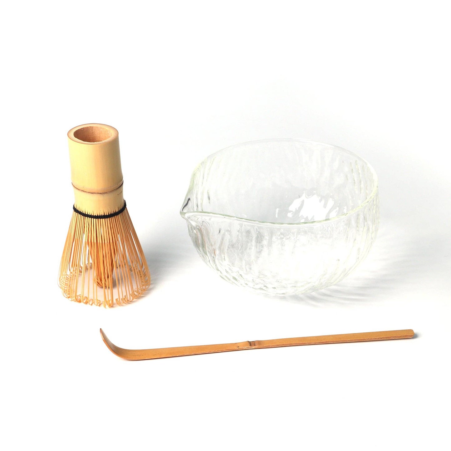 Bamboo whisk and glass bowl on a white background