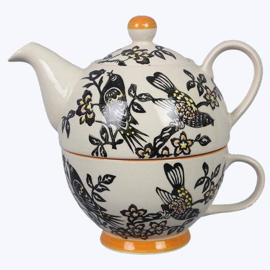 Ceramic teapot with bird and floral design on a white background