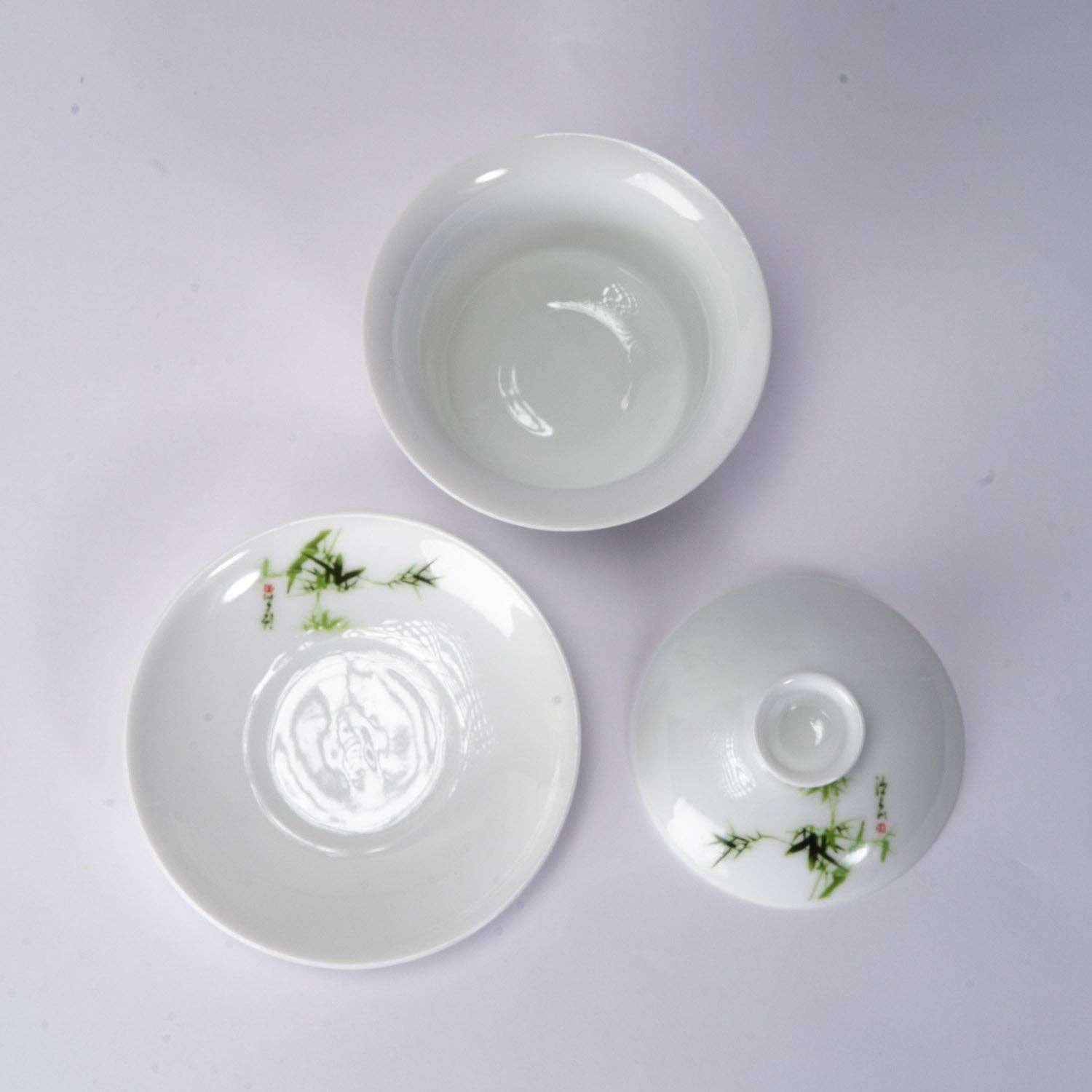 Three white ceramic bowls with floral designs on a light gray background