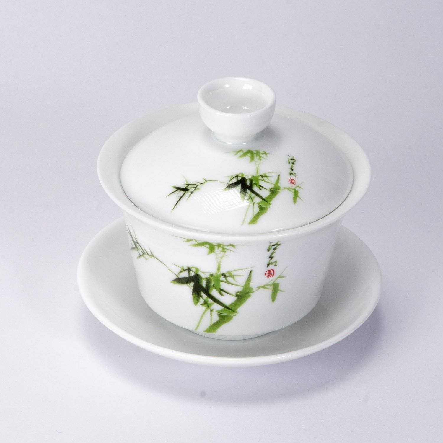 White ceramic teapot with green bamboo design on a white background
