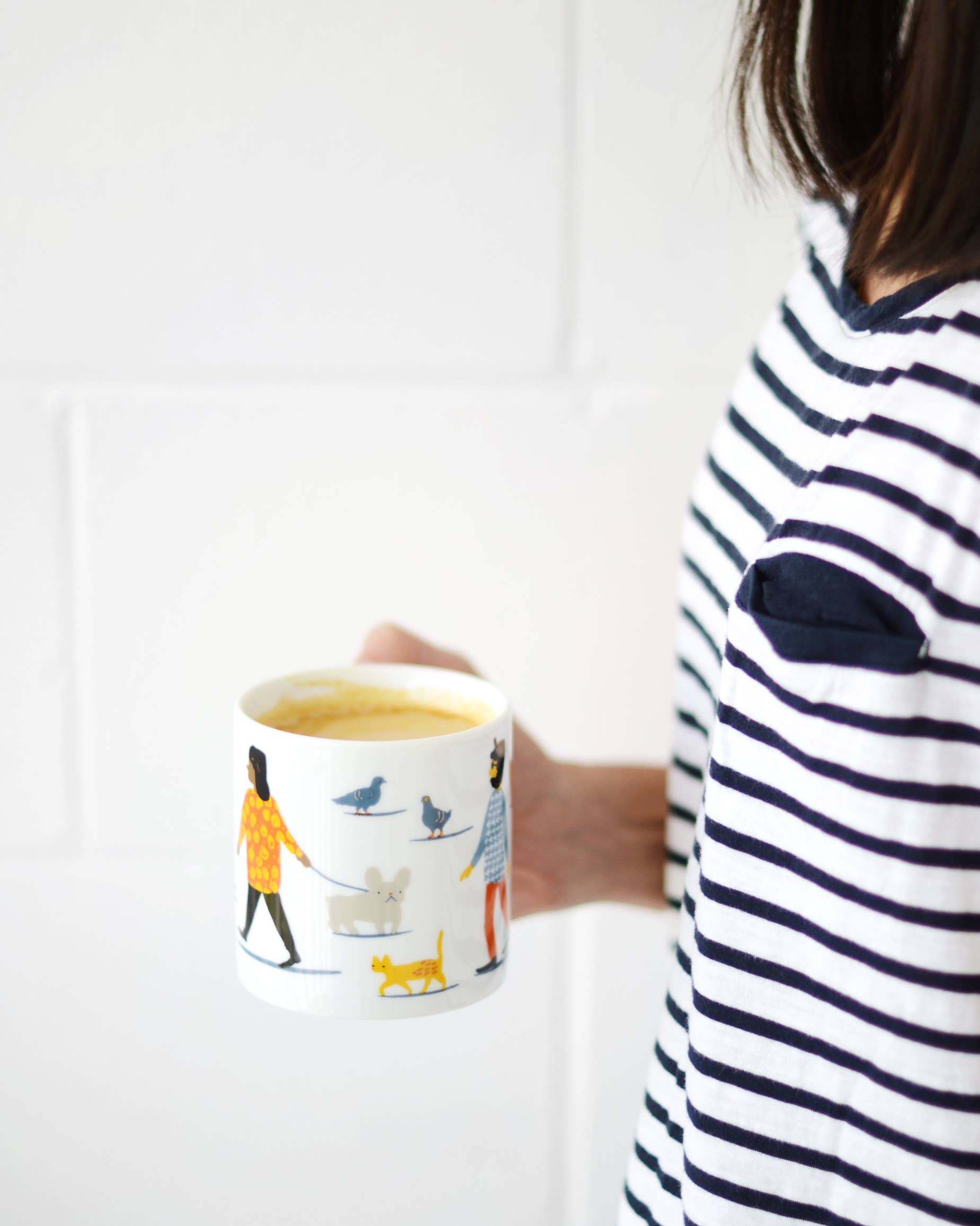 image of hustle and bustle mug being held in hand of a woman