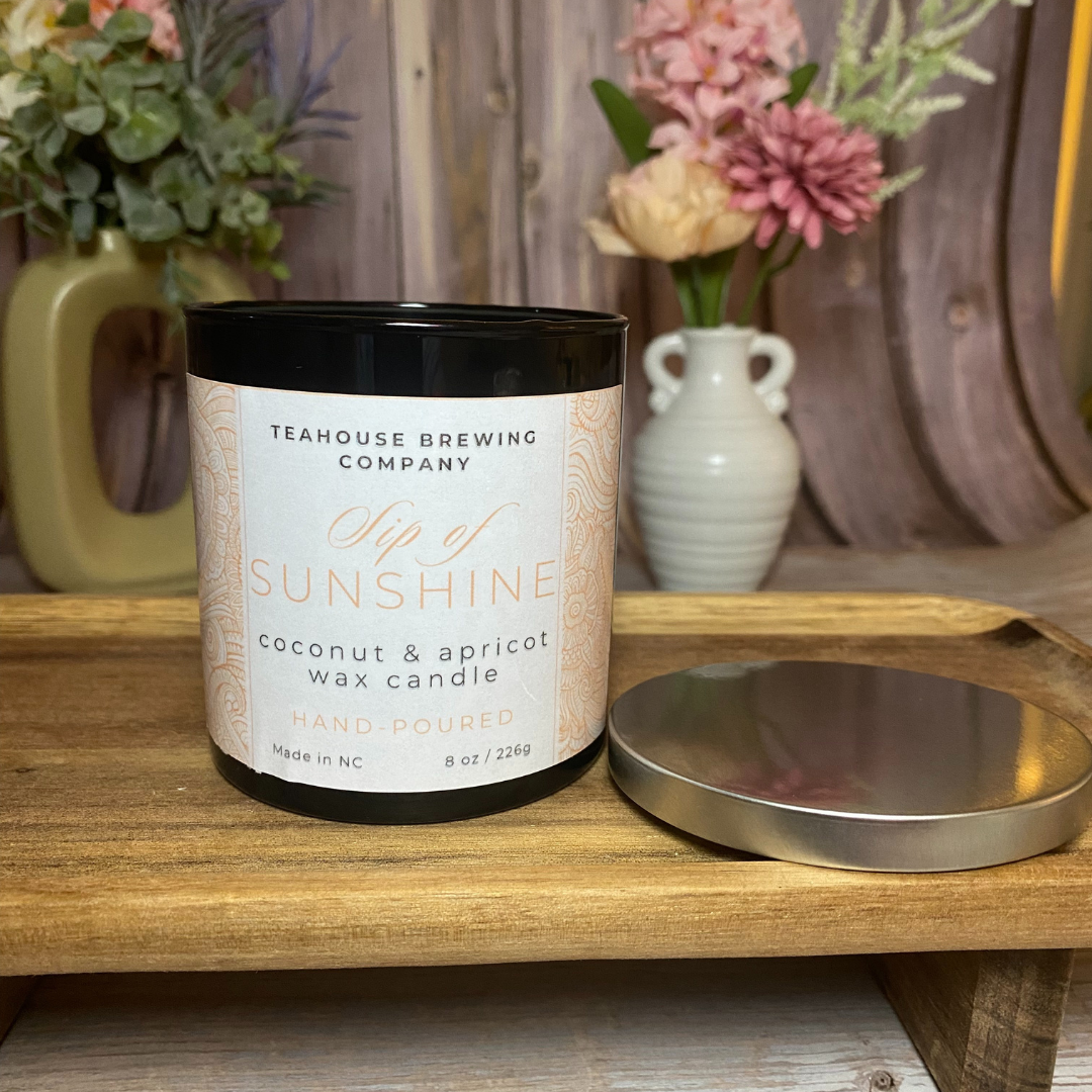 image of "sip of sunshine" tea scented candle in black container with lid