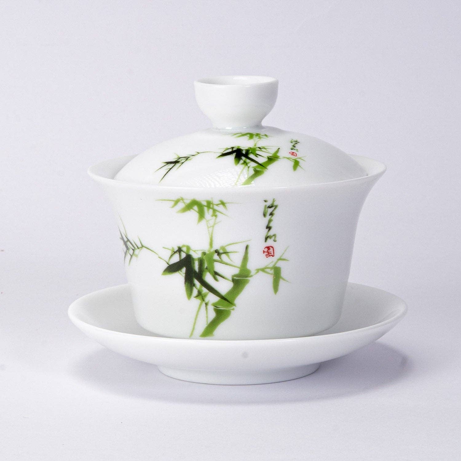 White teacup with green bamboo design on a white background