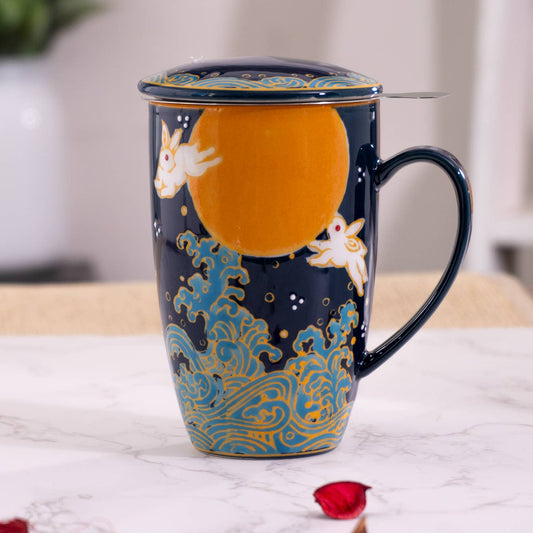 A tall ceramic mug with a blue and gold moon rabbit design, including a lid and a tea infuser.