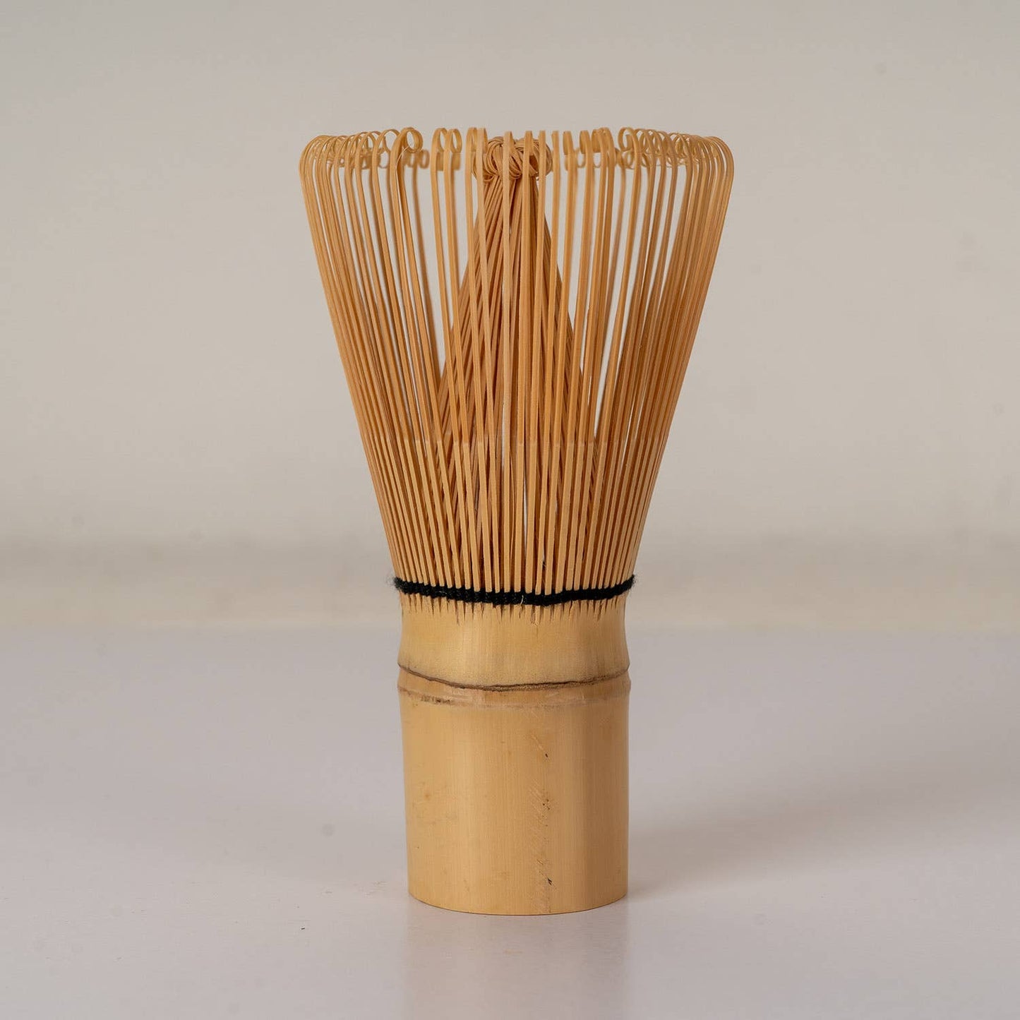 Bamboo whisk on a plain background